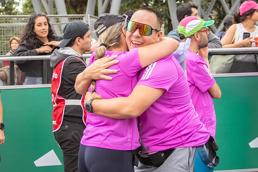 Corredores celebrando y abrazándose tras una carrera, reflejo de los beneficios del running para la salud mental y el bienestar emocional.