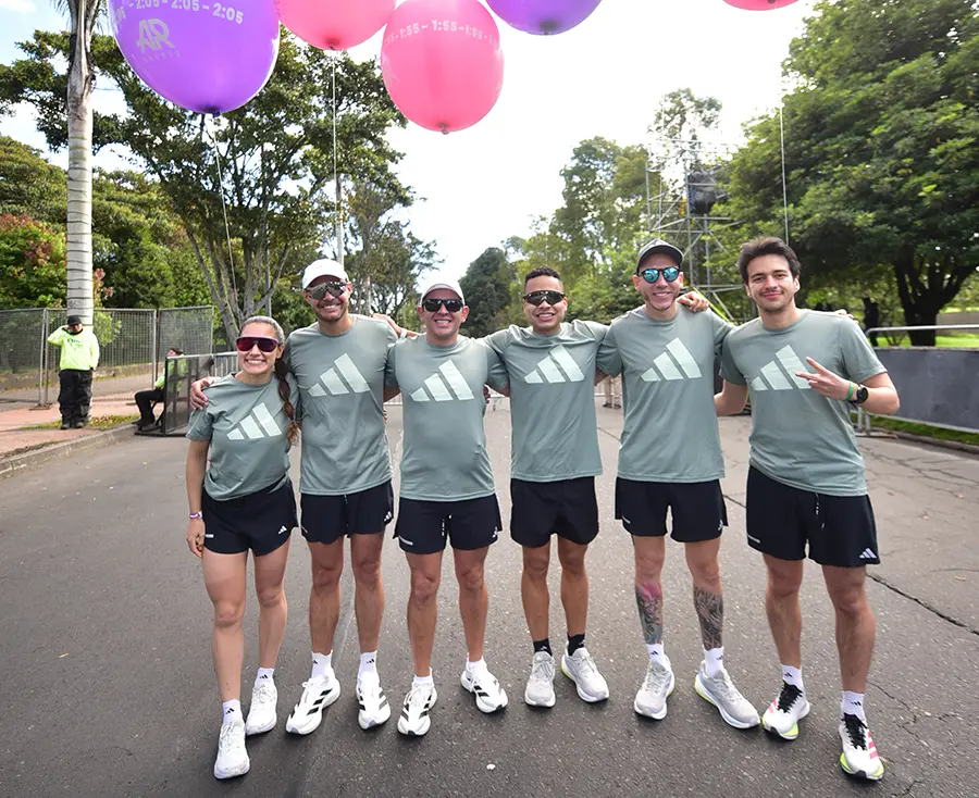 Grupo de corredores realizando fondo largo en parque urbano
