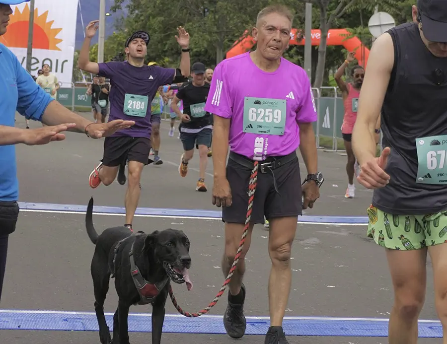 Corredor realizando la media maratón de Bogotá junto a su perro