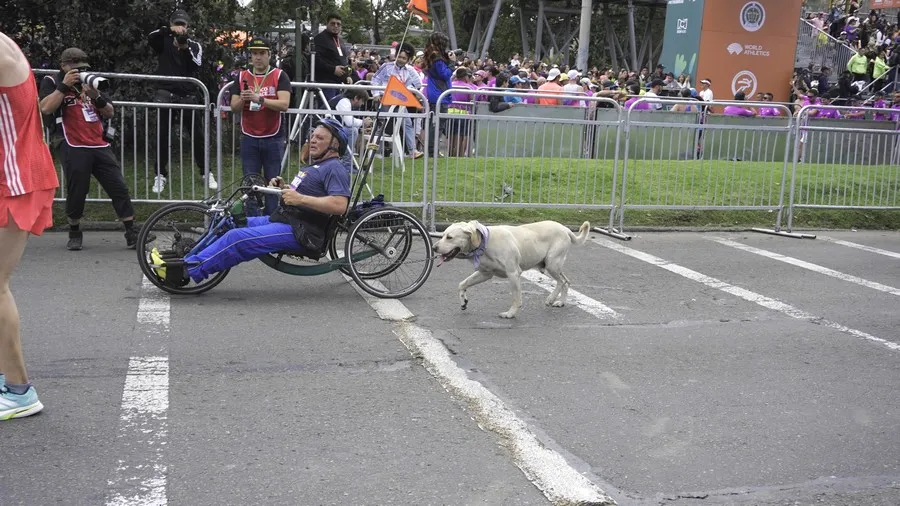 Atleta con discapacidad realizando la media maratón de Bogotá 2025 junto a su perro
