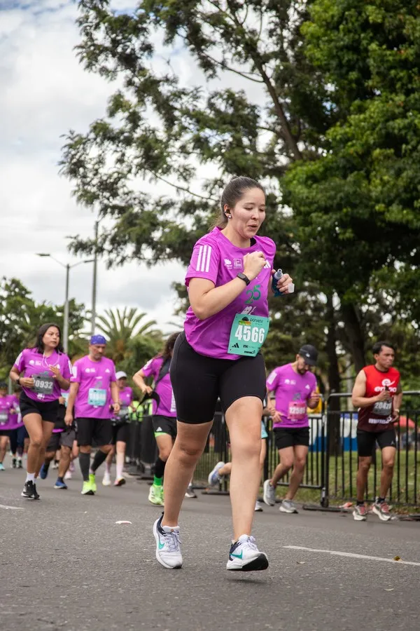 Corredora en la media maratón de Bogotá 2025 muy contenta con música