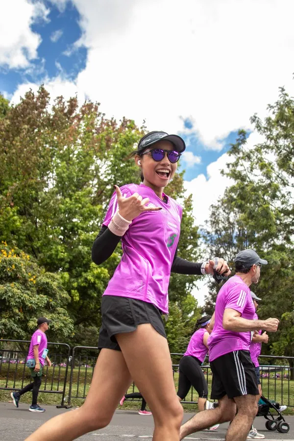 Corredora con una gran actitud durante la media maratón de Bogotá 2025 escuchando música