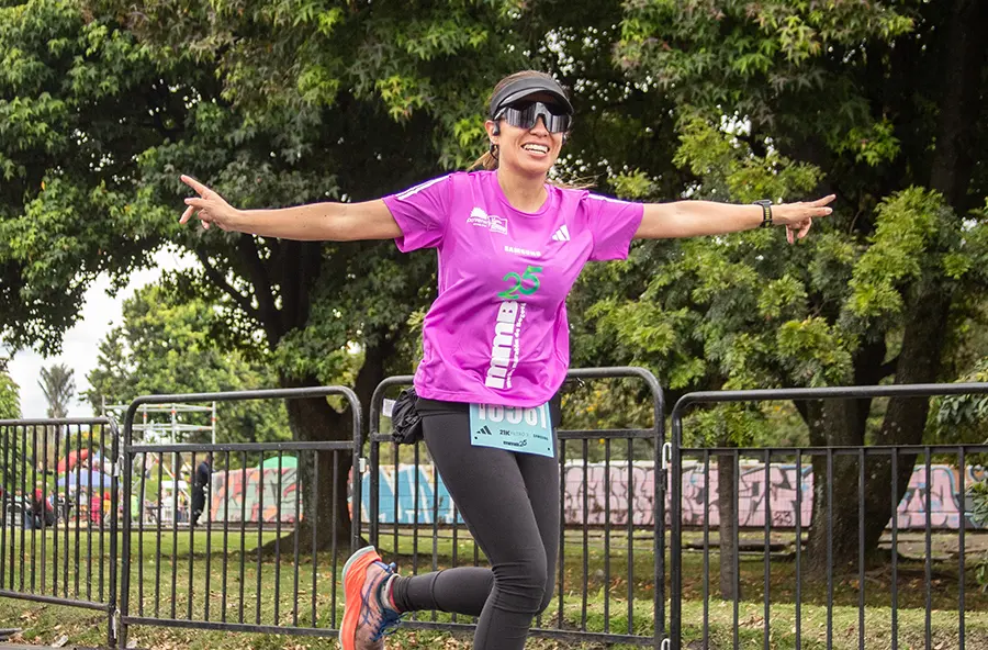 Mujer corriendo con confianza durante entrenamiento de media maratón