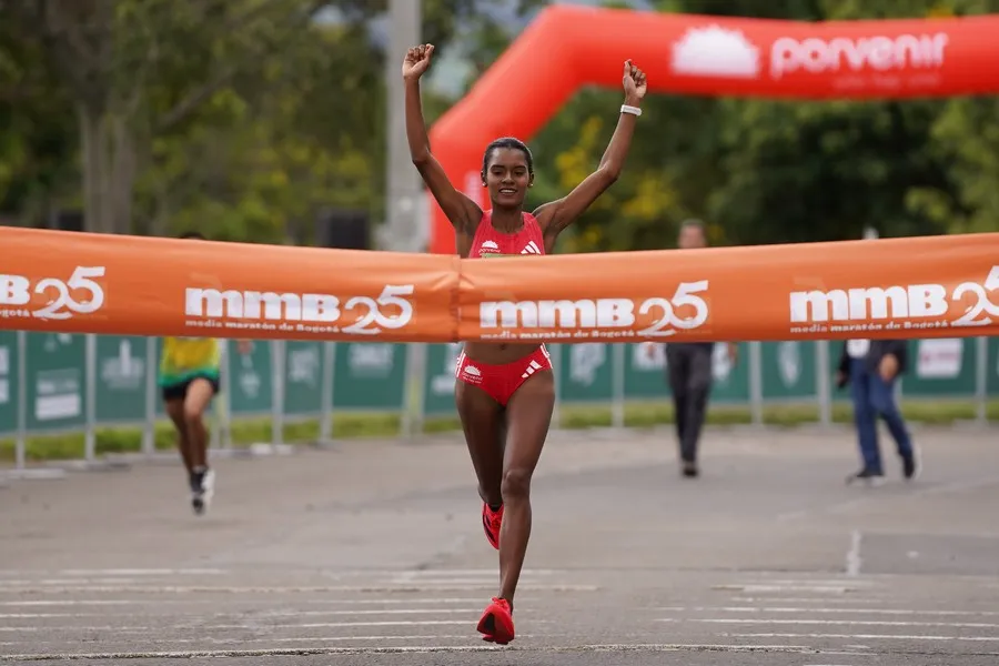 Mujer cruzando orgullosa su primera meta de carrera de 10 kilómetros
