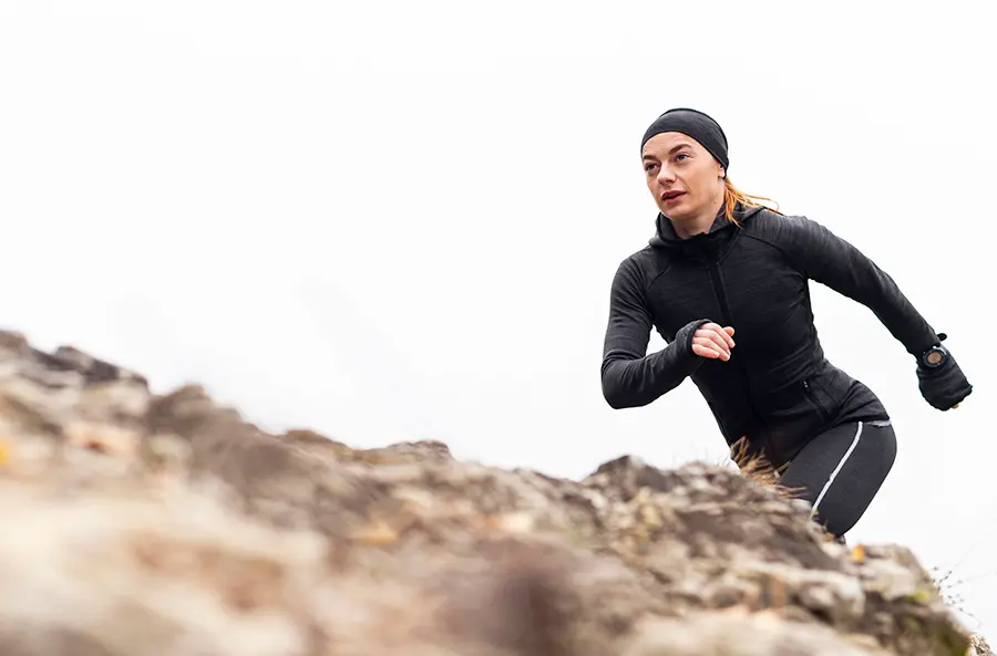Atleta subiendo pendiente con técnica correcta durante sesión de entrenamiento en cuestas