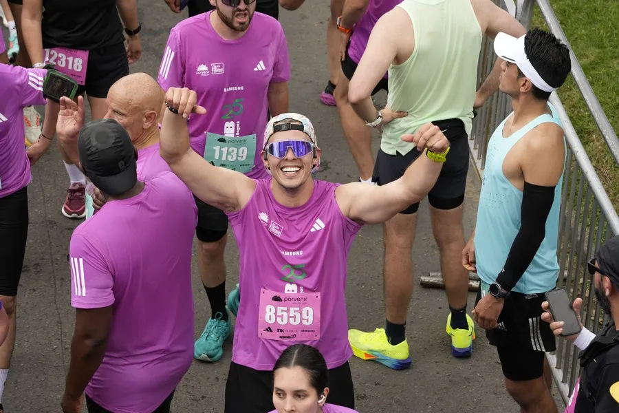 Corredor novato celebrando completar primer 10K después de meses de entrenamiento gradual
