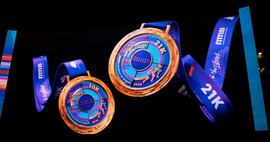 Medallas oficiales 10K y 21K de la media maratón de Bogotá 2026 con listón azul y diseño vibrante