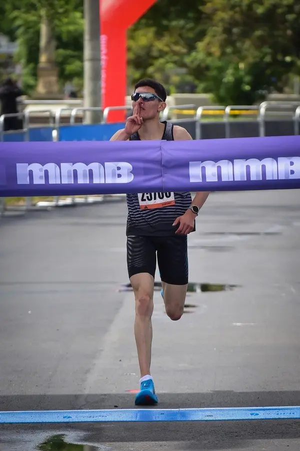 Dylan Carrasco cruzando la meta como campeón de 10K Abierta Masculino en la Carrera de la mmB 2026