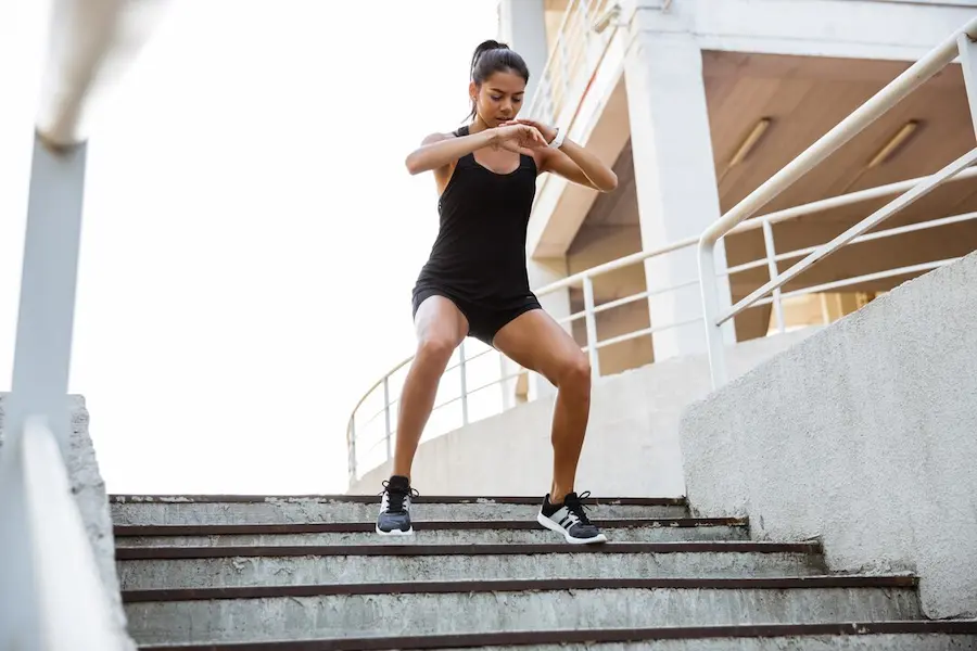 Runner bajando escaleras de manera controlada como entrenamiento excéntrico de cuádriceps