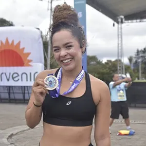 Corredora sonríe después de completar la carrera en Bogotá.